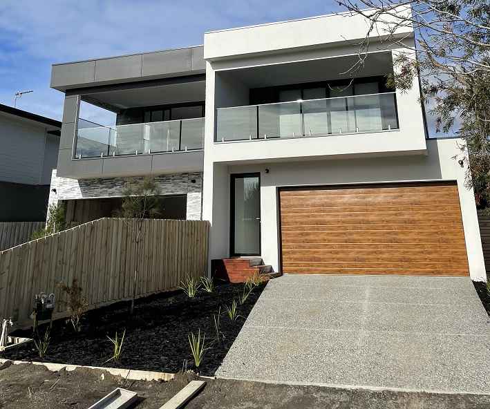 Modern two-storey home lit up at dusk